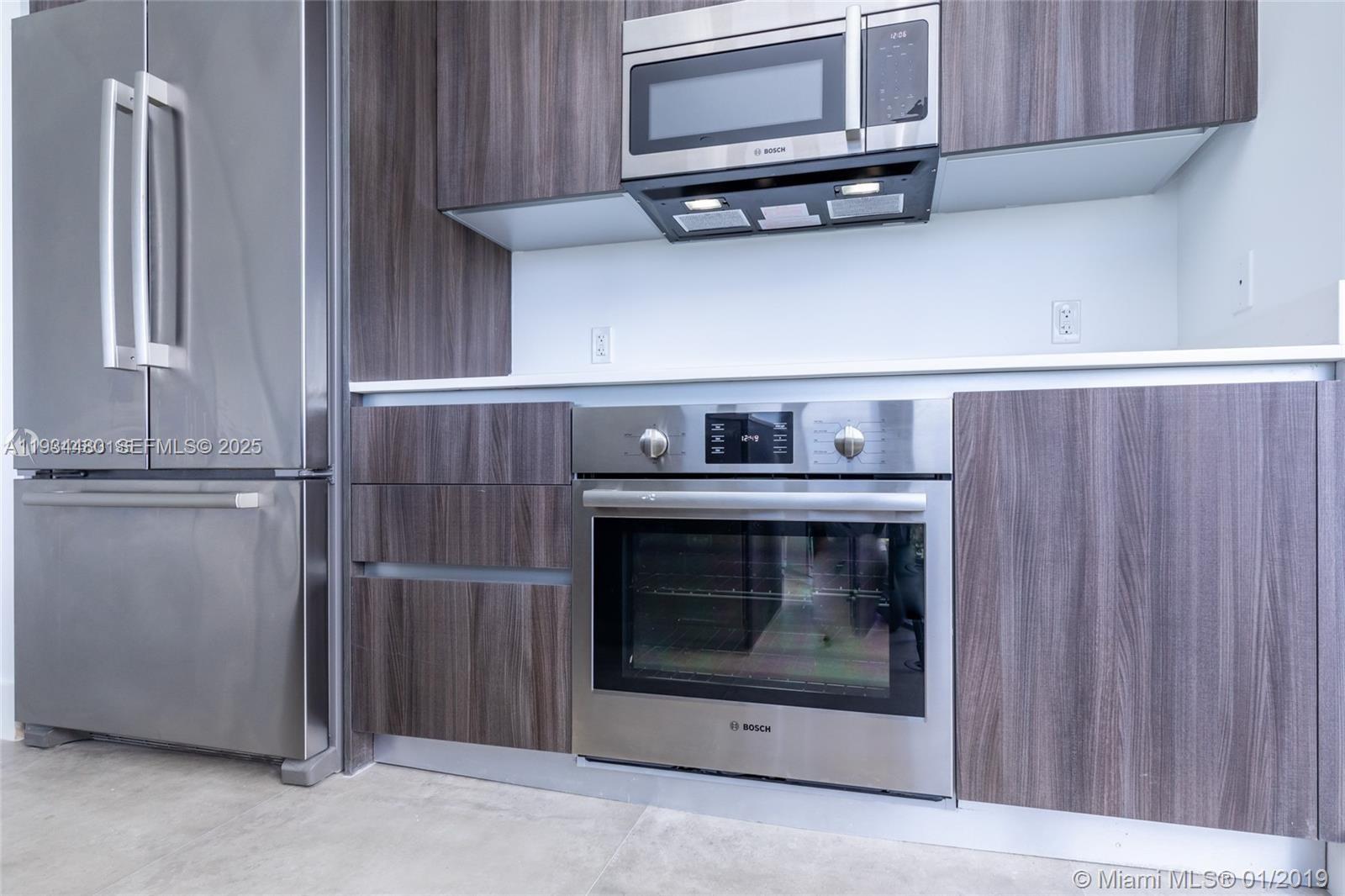 488 Northeast 18th Street, Unit 1600 Miami, FL 33132 - Photo 14 of 34 a kitchen with cabinets and stainless steel appliances