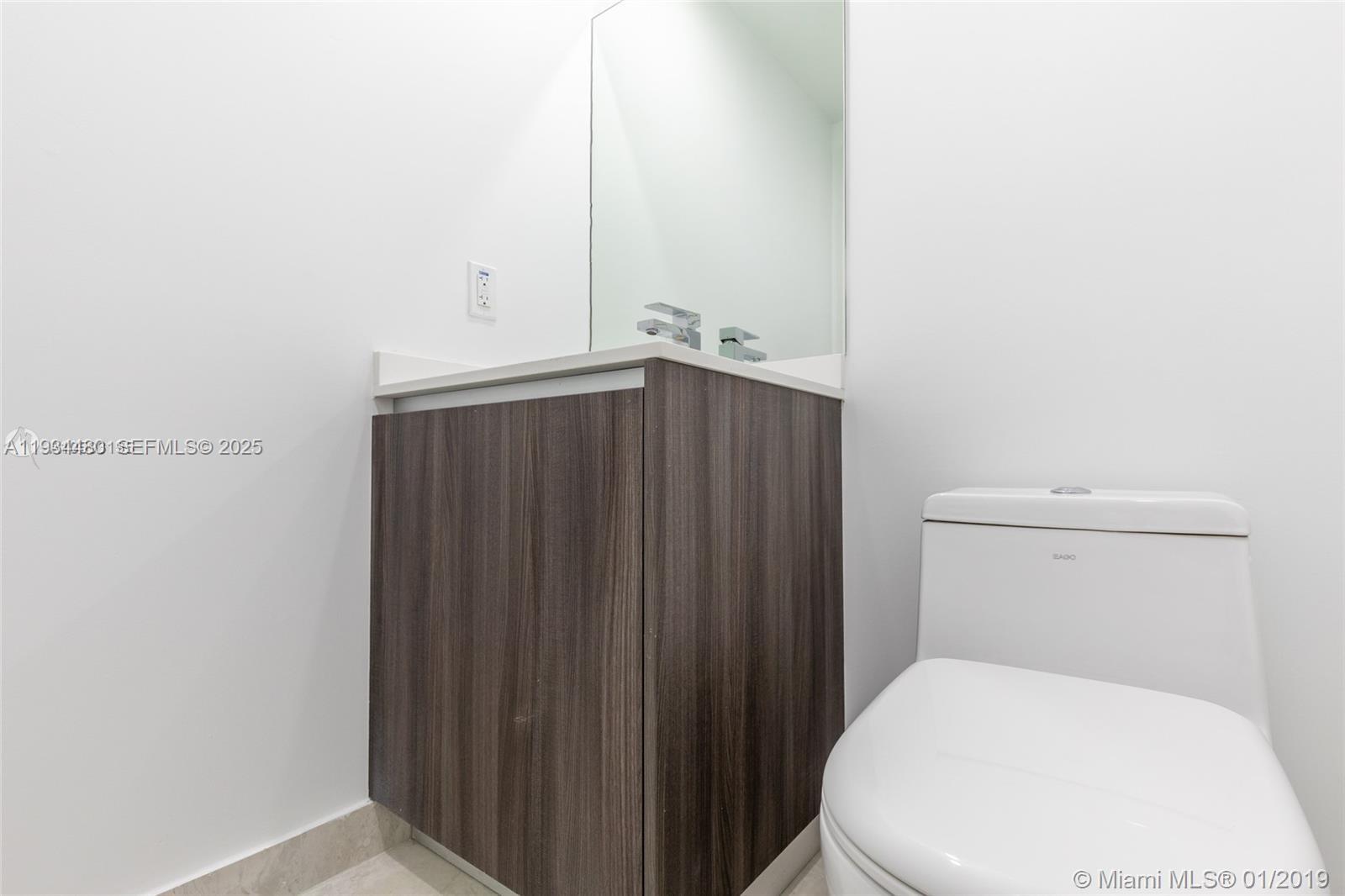 488 Northeast 18th Street, Unit 1600 Miami, FL 33132 - Photo 20 of 34 a bathroom with a toilet and a wooden door