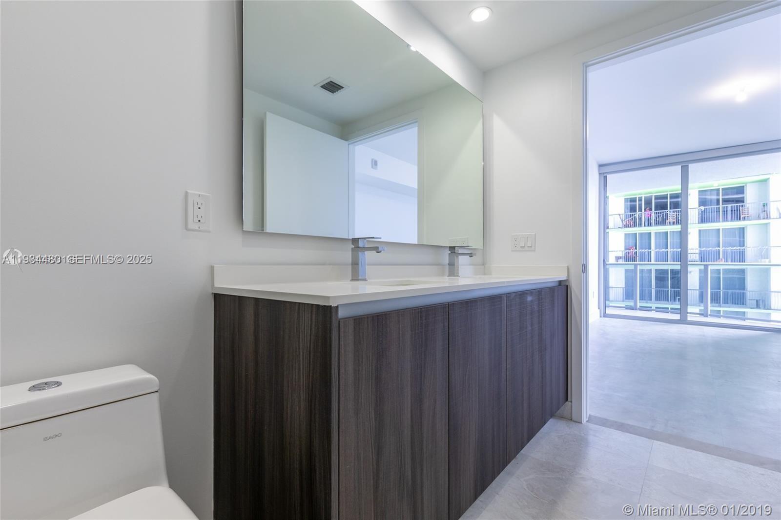 488 Northeast 18th Street, Unit 1600 Miami, FL 33132 - Photo 21 of 34 a bathroom with a sink vanity and a toilet