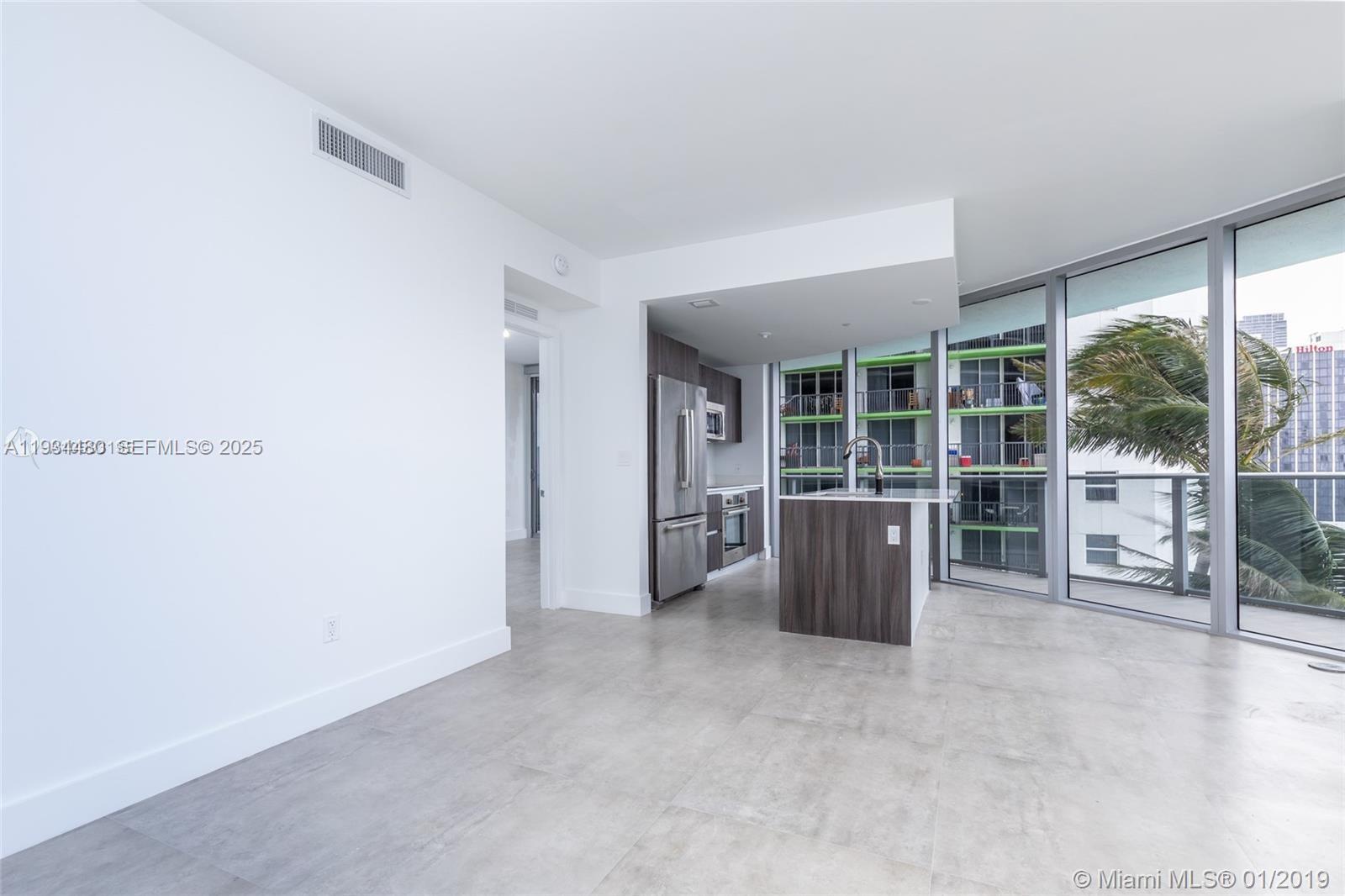 488 Northeast 18th Street, Unit 1600 Miami, FL 33132 - Photo 9 of 34 an empty room with floor to ceiling window and wooden floor
