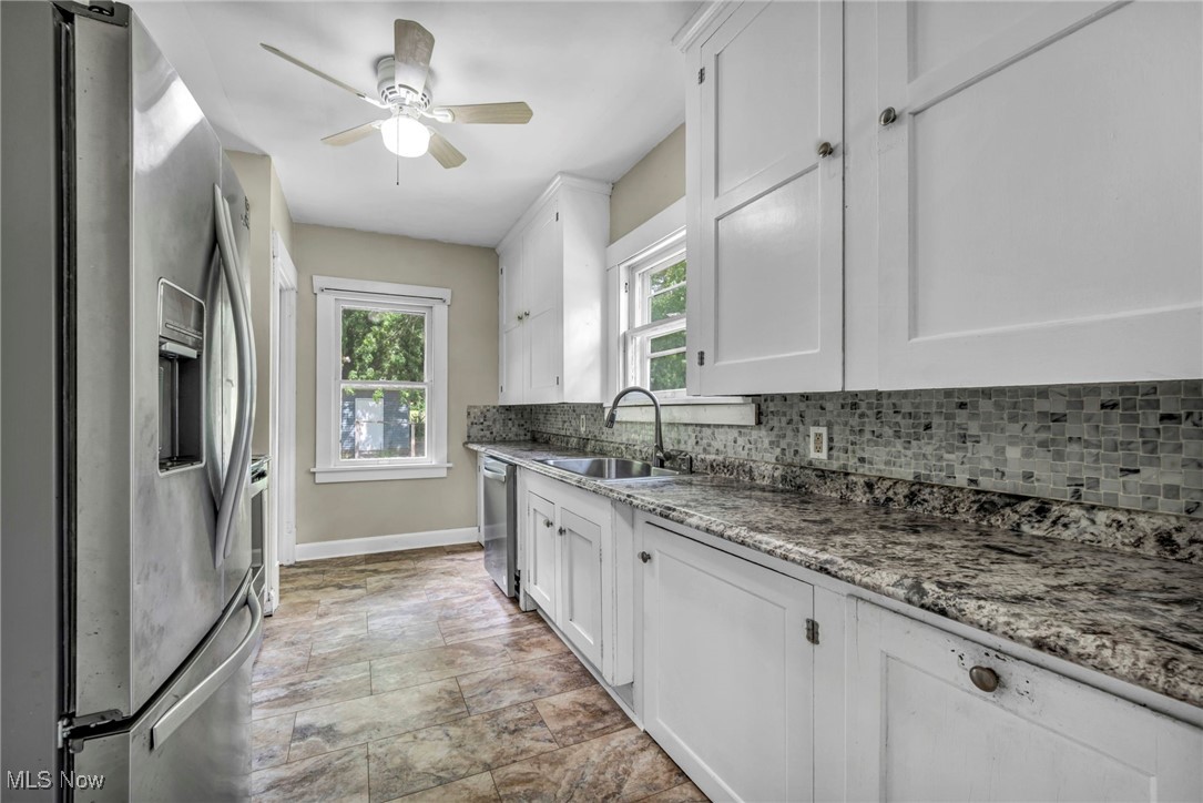 1425 Keefer Road Girard, OH 44420 - Photo 6 of 37 Kitchen featuring stainless steel appliances, decorative backsplash, white cabinets, stone finish flooring, and a ceiling fan