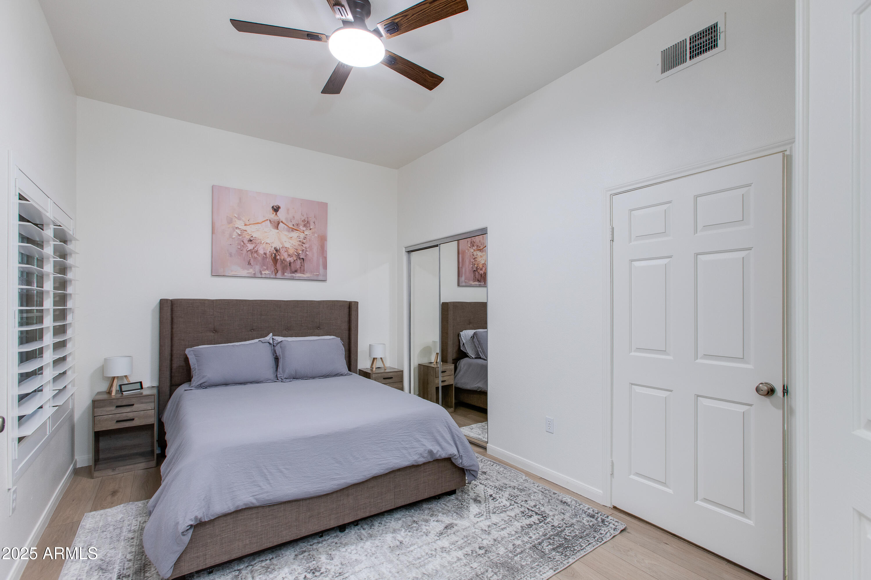 8245 East Bell Road, Unit 102 Scottsdale, AZ 85260 - Photo 13 of 21 a bedroom with a bed and a chandelier
