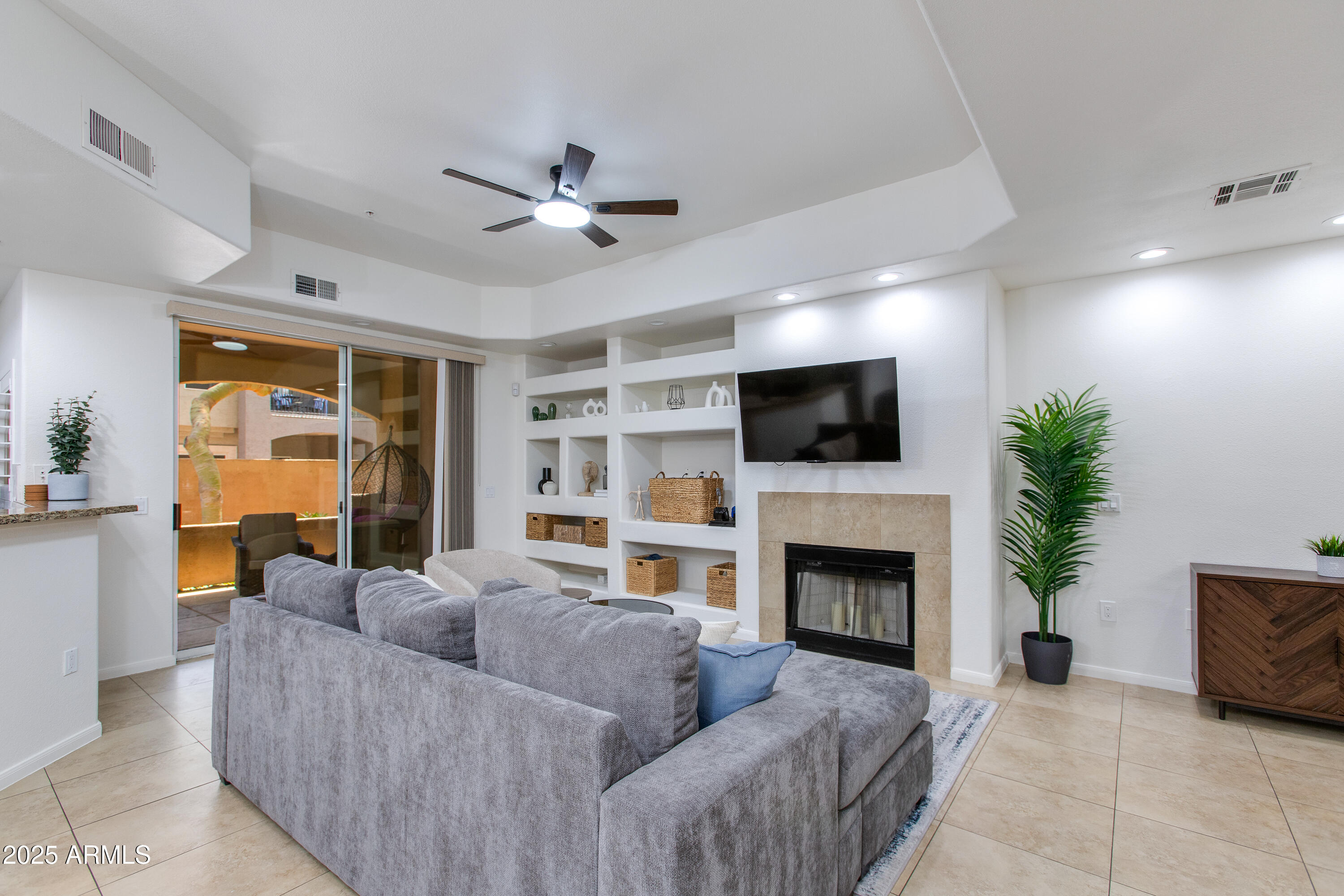 8245 East Bell Road, Unit 102 Scottsdale, AZ 85260 - Photo 5 of 21 a living room with furniture a flat screen tv and a fireplace