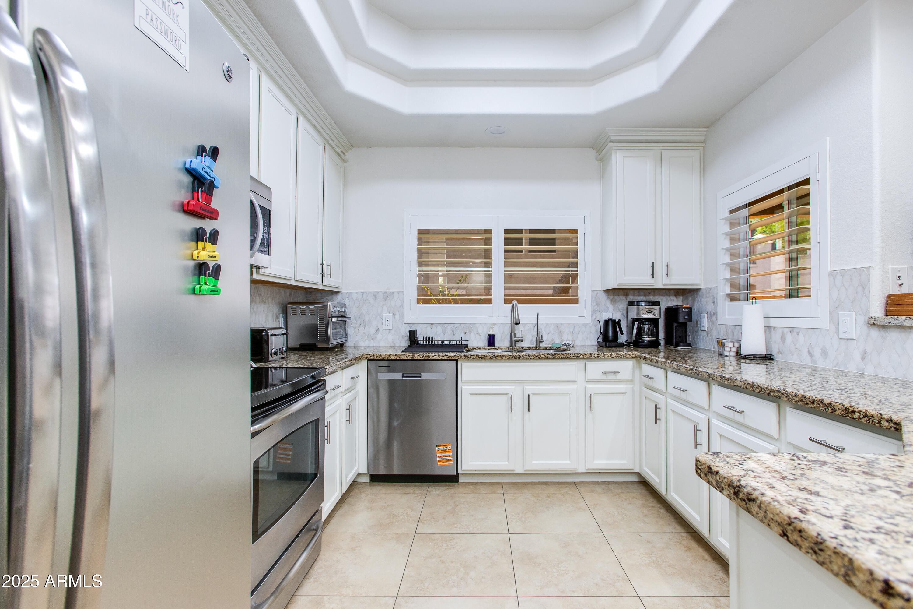 8245 East Bell Road, Unit 102 Scottsdale, AZ 85260 - Photo 8 of 21 a kitchen with granite countertop white cabinets and white appliances
