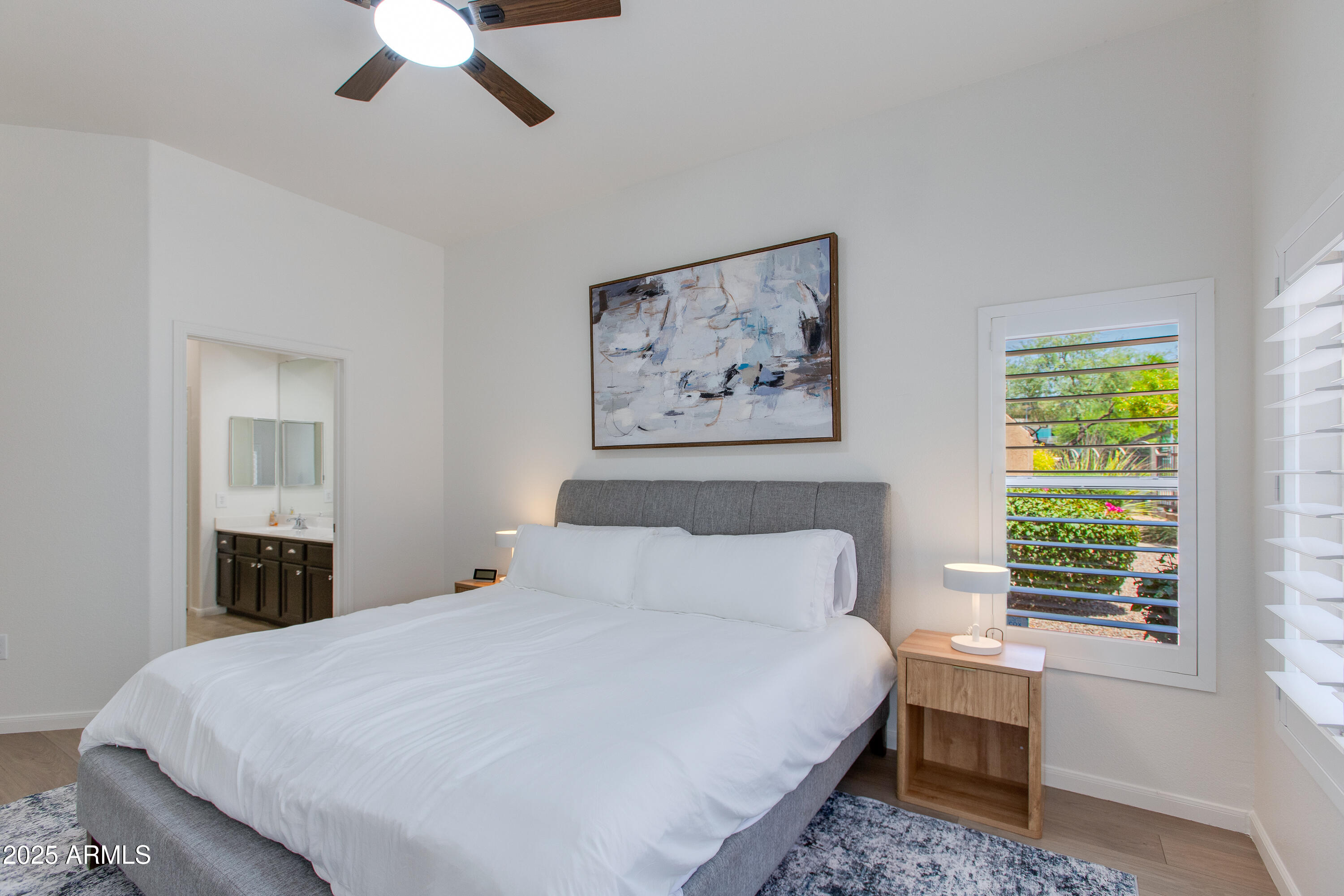 8245 East Bell Road, Unit 102 Scottsdale, AZ 85260 - Photo 10 of 21 a bedroom with a large bed and a window