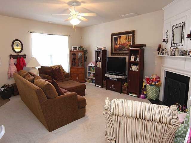 8137 Rhiannon Road Raleigh, NC 27613 - Photo 3 of 9 a living room with furniture a flat screen tv and a fireplace