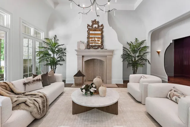 a living room with furniture a fireplace and lots of windows