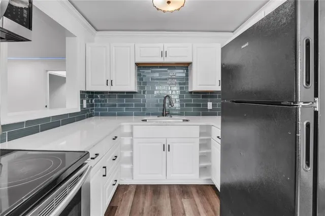 an empty room with wooden floor ceiling fan and windows