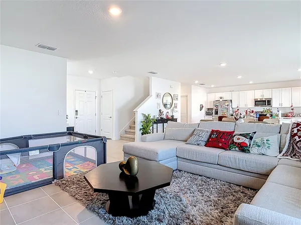 a living room with furniture and a view of kitchen