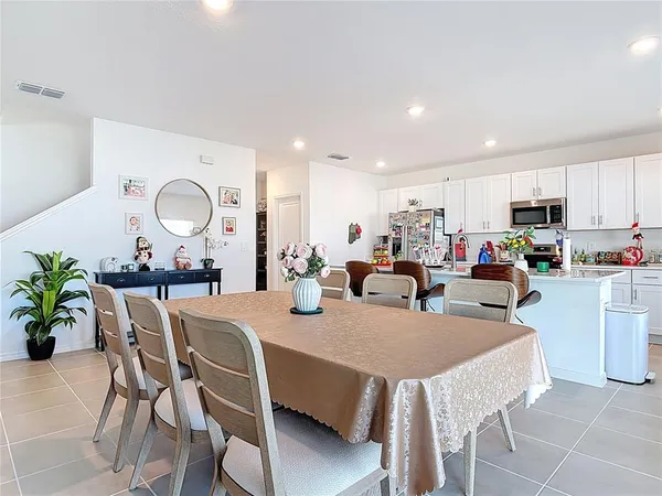 a dining room top with furniture a potted plant and kitchen view