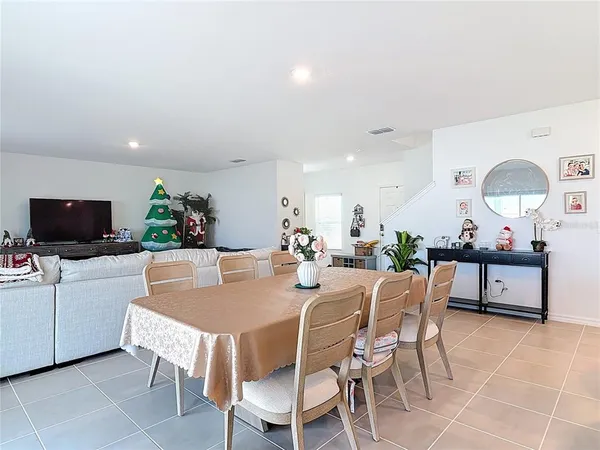 a dining room with furniture and a flat screen tv