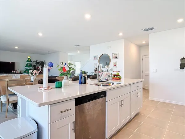 a kitchen with a sink counter top space and living room view