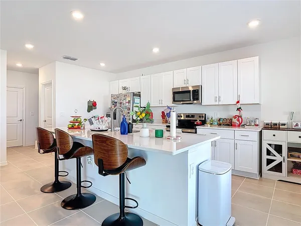 a kitchen with microwave a stove and chairs