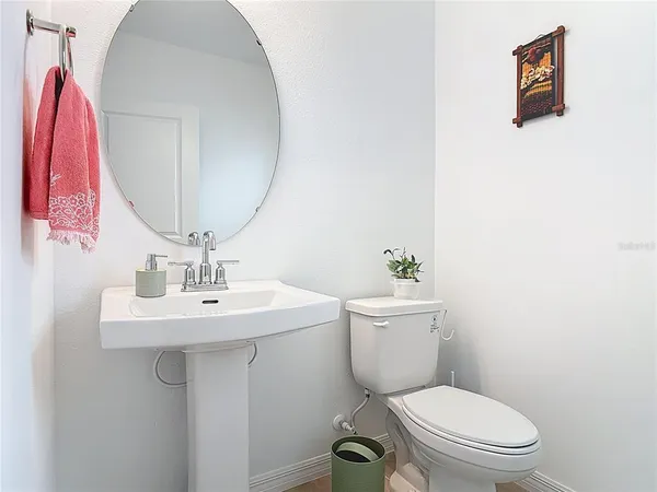 a bathroom with a toilet a sink and mirror