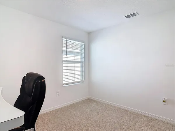 an empty room with a chair and a window