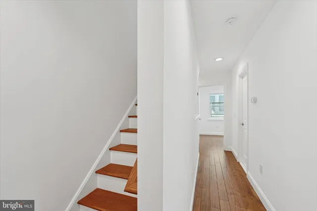 a view of a hallway with entryway and stairs