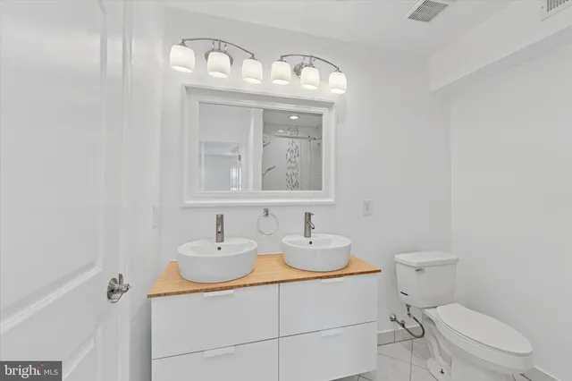 a bathroom with a sink a toilet and a mirror