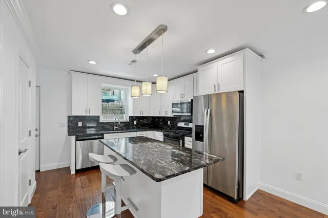 a kitchen with stainless steel appliances granite countertop a refrigerator and a stove top oven