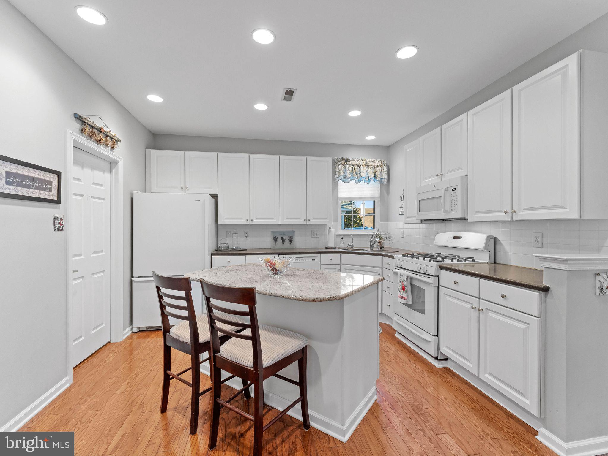 1707 Hulnick Road, Unit 43830 Coatesville, PA 19320 - Photo 15 of 36 a kitchen with stainless steel appliances granite countertop a white table chairs and a refrigerator