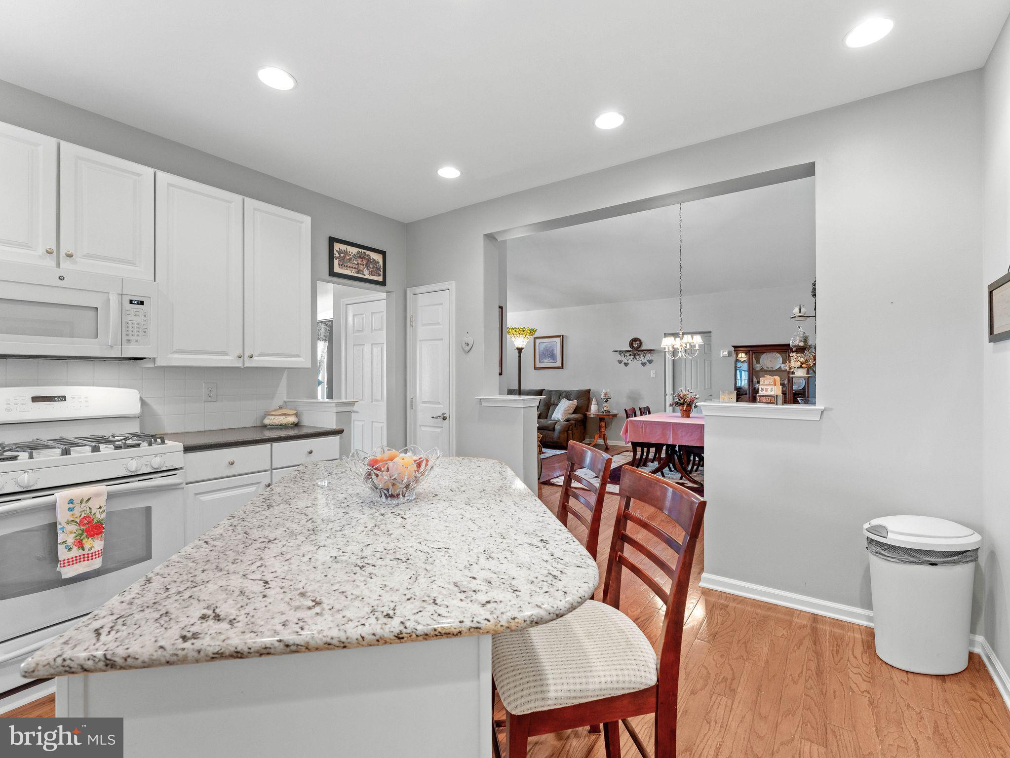 1707 Hulnick Road, Unit 43830 Coatesville, PA 19320 - Photo 19 of 36 a kitchen with stainless steel appliances granite countertop a table chairs sink and cabinets