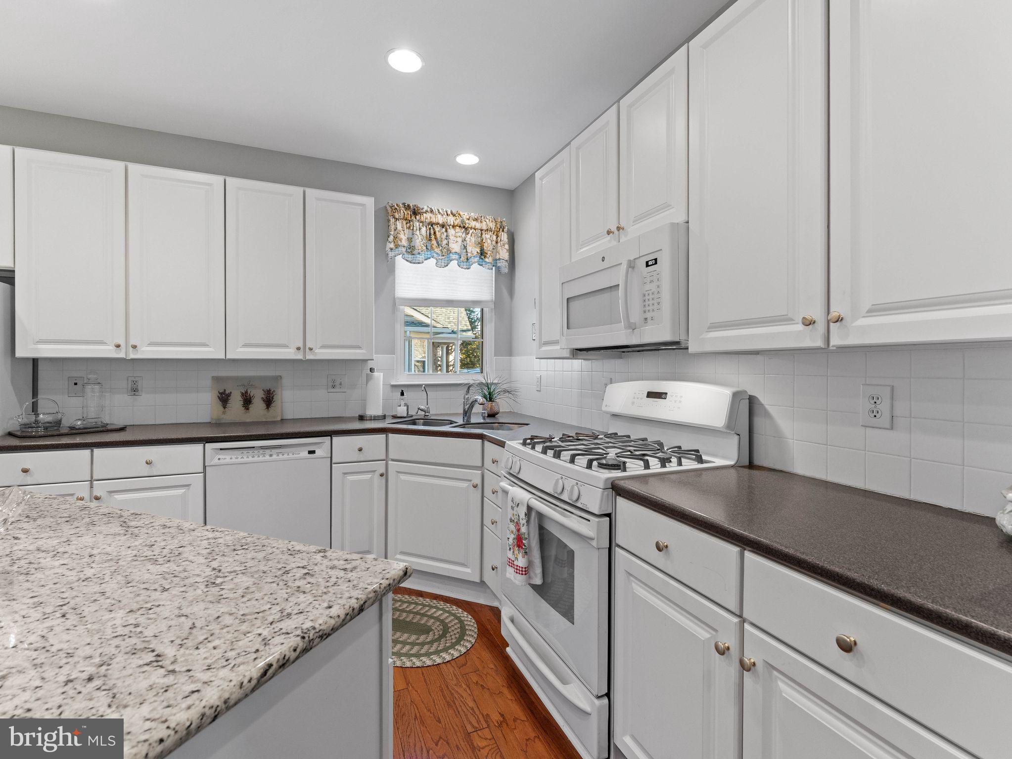 1707 Hulnick Road, Unit 43830 Coatesville, PA 19320 - Photo 22 of 36 a kitchen with granite countertop white cabinets and white appliances