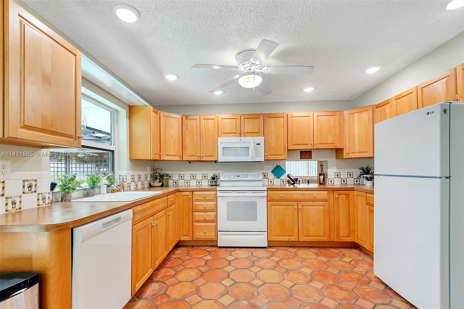 13120 Southwest 117th Street Miami, FL 33186 - Photo 5 of 29 a kitchen with a sink a refrigerator and cabinets
