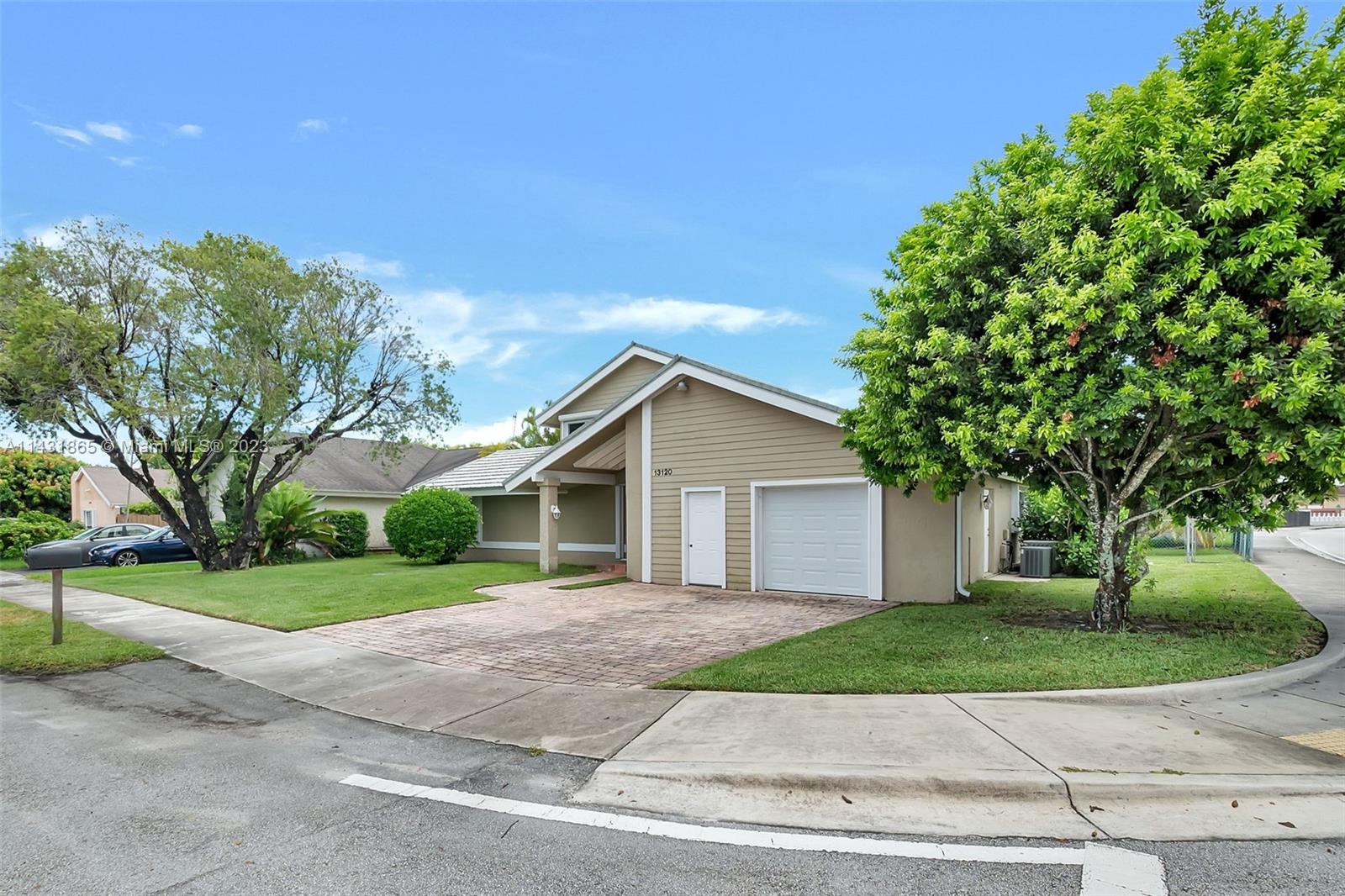 13120 Southwest 117th Street Miami, FL 33186 - Photo 10 of 29 a front view of a house with a yard and garage