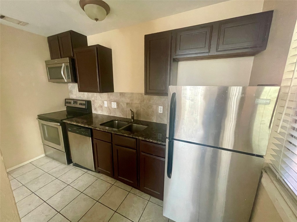 a kitchen with stainless steel appliances granite countertop a refrigerator and a sink