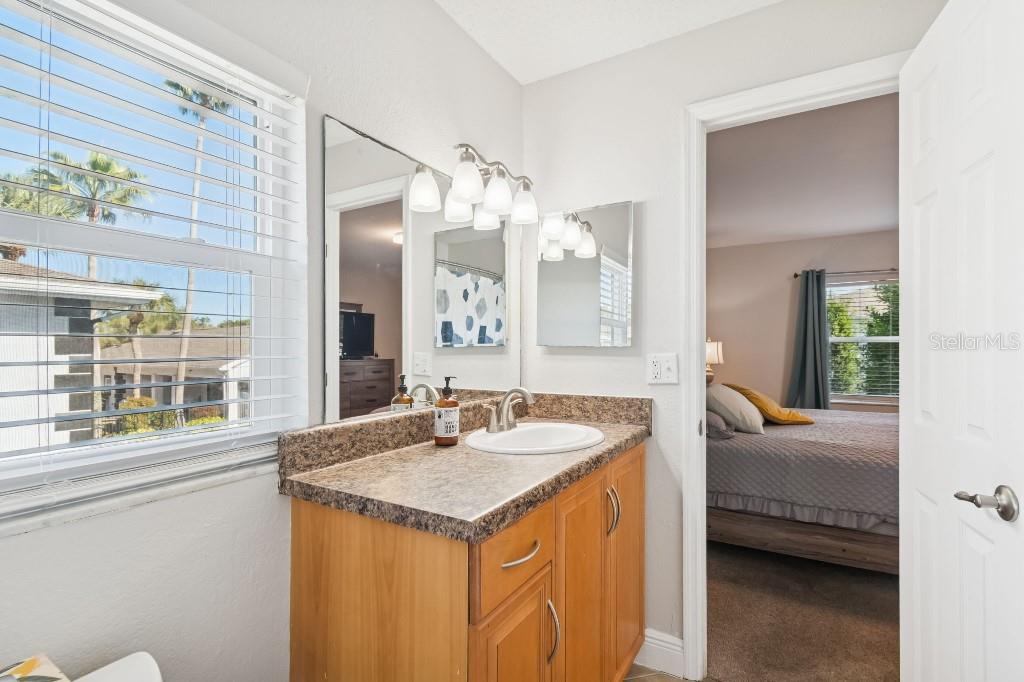 13125 Wilcox Road, Unit 6205 Largo, FL 33774 - Photo 31 of 48 a en suite bathroom with a granite countertop sink and a large mirror