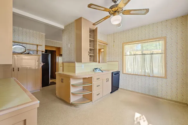 a kitchen with a refrigerator a sink and dishwasher with white cabinets