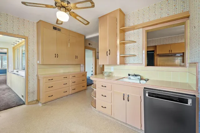 a kitchen with cabinets stainless steel appliances and a chandelier