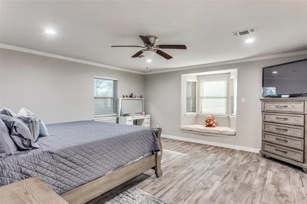 a bedroom with a bed chandelier and a window