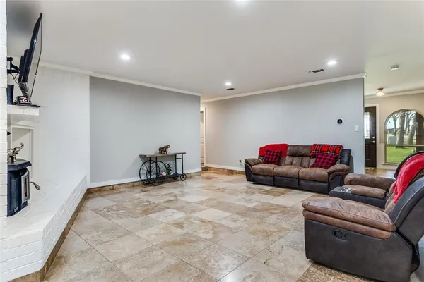 a living room with furniture a flat screen tv and a fireplace
