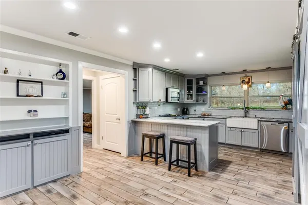a kitchen with stainless steel appliances granite countertop a sink stove and refrigerator
