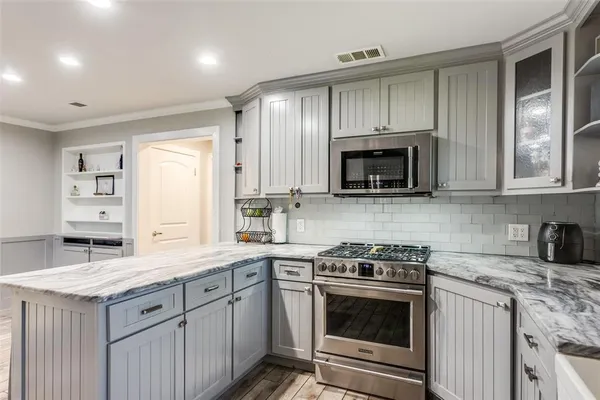a kitchen with appliances a sink and cabinets