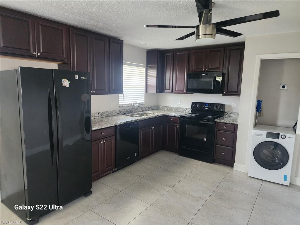 3325 Airport Road North, Unit N8 Naples, FL 34105 - Photo 5 of 22 a kitchen with stainless steel appliances granite countertop a refrigerator a sink dishwasher a stove and black cabinets