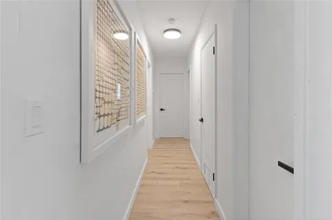 a view of a hallway with wooden floor and door