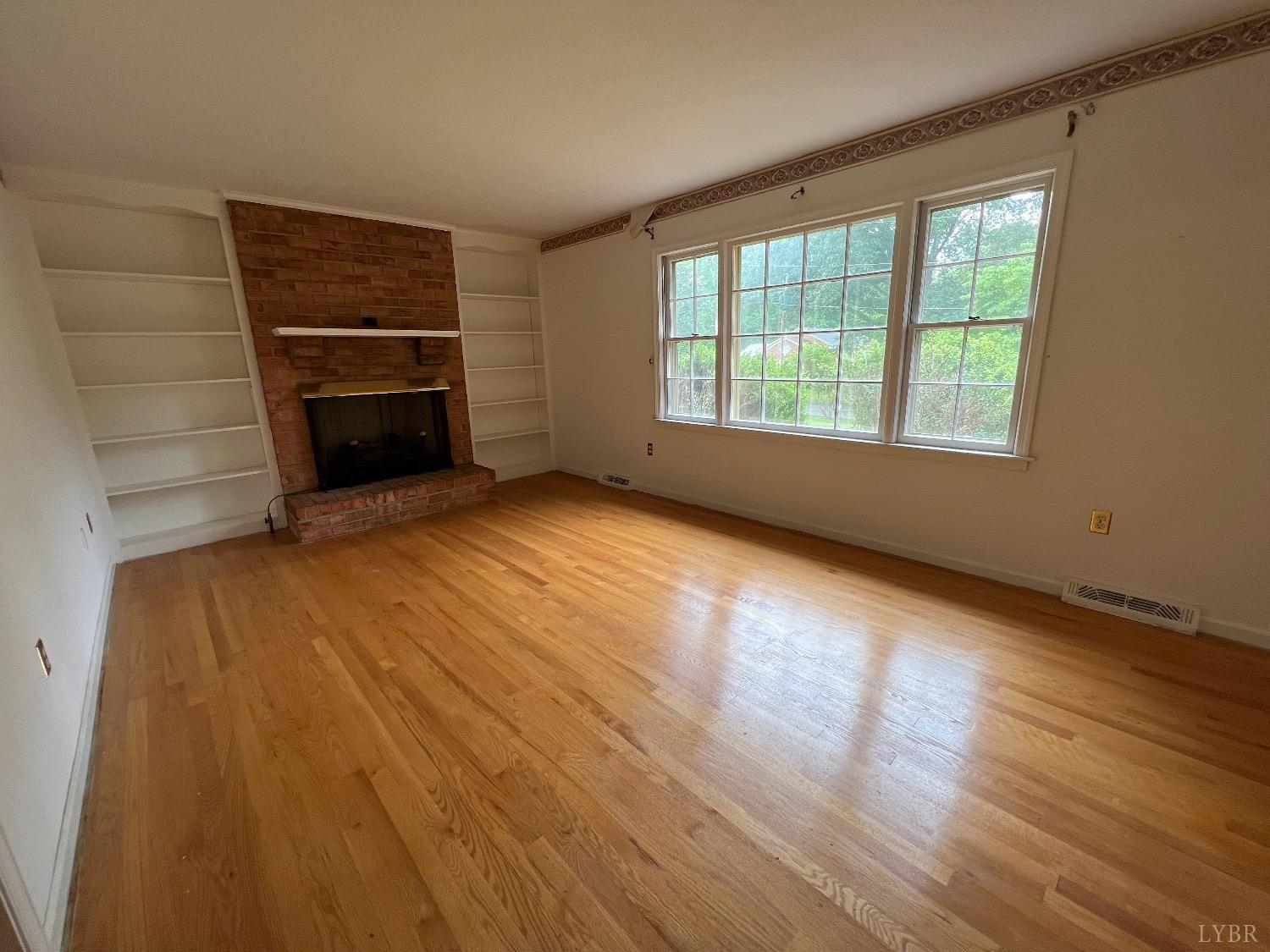 214 Blue Ridge Lane Amherst, VA 24521 - Photo 8 of 36 a view of empty room with wooden floor and fireplace
