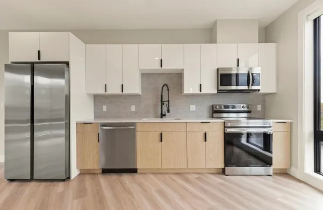 a kitchen with stainless steel appliances a stove a sink and a refrigerator