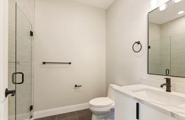 a bathroom with a granite countertop sink toilet and a mirror