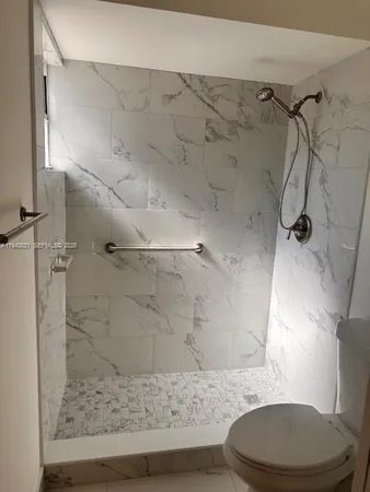 a bathroom with a toilet and a shower