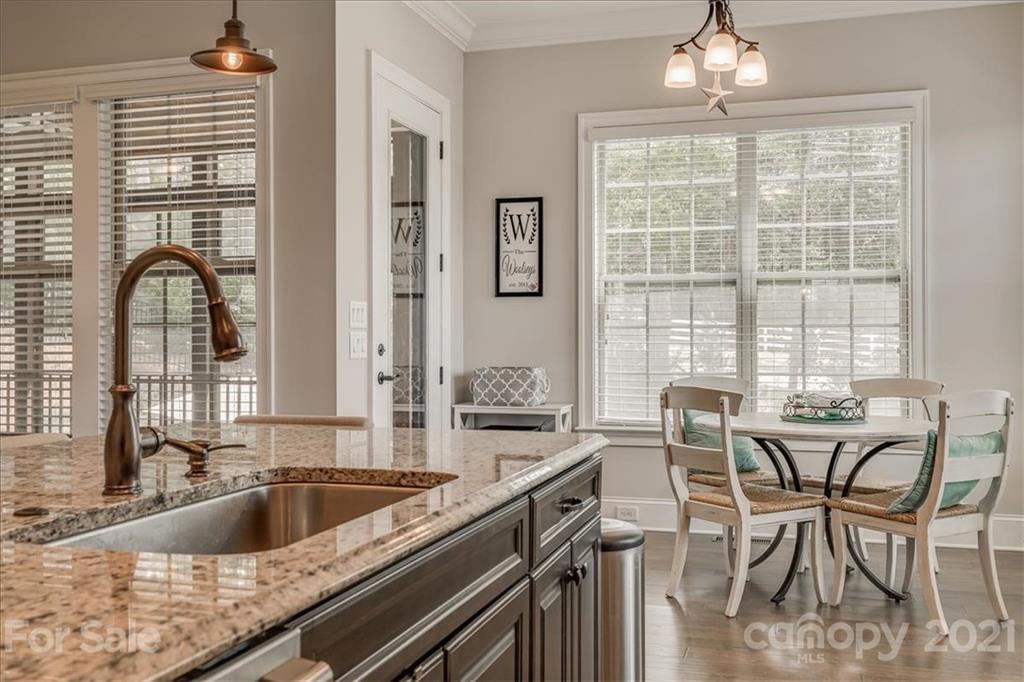 620 Zinnia Way Tega Cay, SC 29708 - Photo 13 of 39 a view of a kitchen with granite countertop a sink stainless steel appliances and dining table