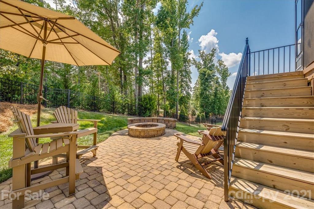 620 Zinnia Way Tega Cay, SC 29708 - Photo 17 of 39 a view of a patio with a table and chairs under an umbrella
