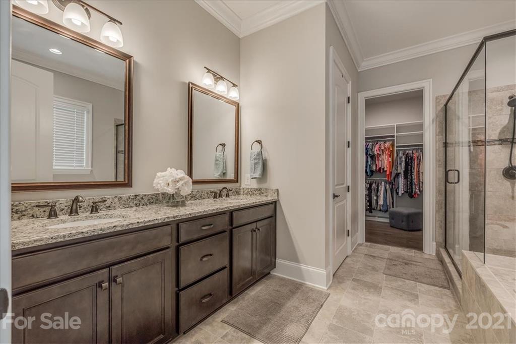 620 Zinnia Way Tega Cay, SC 29708 - Photo 22 of 39 a bathroom with a sink a mirror and a shower