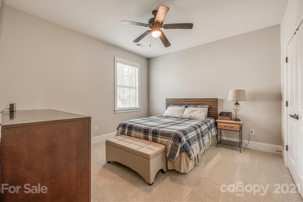 620 Zinnia Way Tega Cay, SC 29708 - Photo 27 of 39 a bedroom with a bed and a chandelier