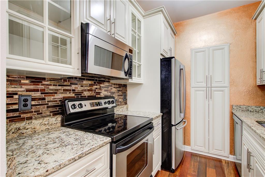 2865 Lenox Road Northeast, Unit 102 Atlanta, GA 30324 - Photo 6 of 35 a kitchen with stainless steel appliances granite countertop a stove and a refrigerator