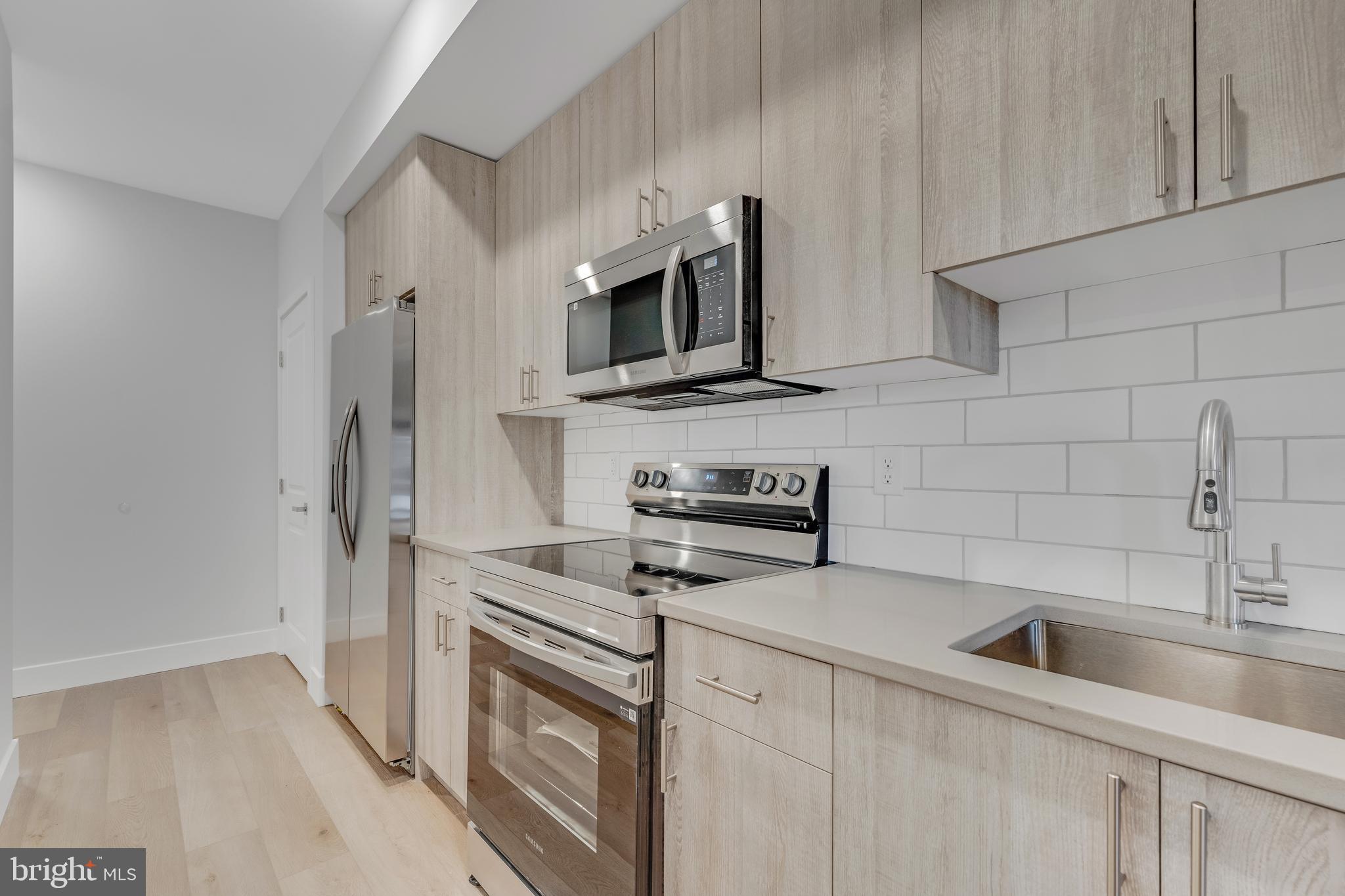 1243 West Westmoreland Street, Unit 2 Philadelphia, PA 19140 - Photo 4 of 18 a kitchen with stainless steel appliances a stove microwave and sink