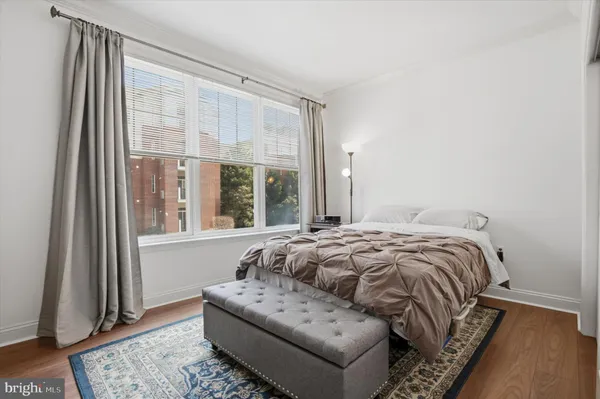a bedroom with a bed and a large window