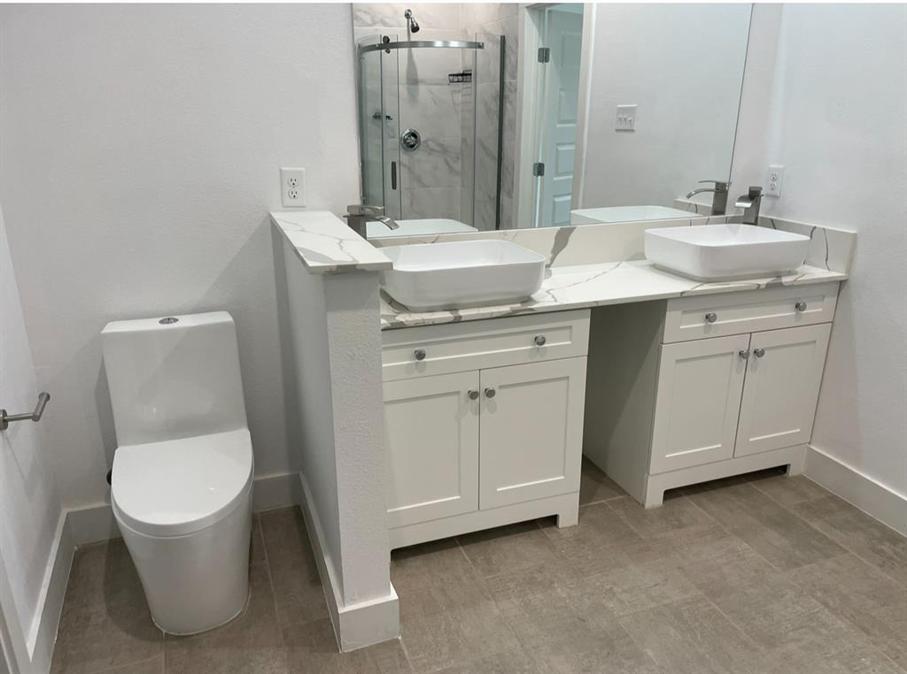 9495 Timberleaf Drive Dallas, TX 75243 - Photo 8 of 11 Bathroom featuring double sink vanity and an enclosed shower