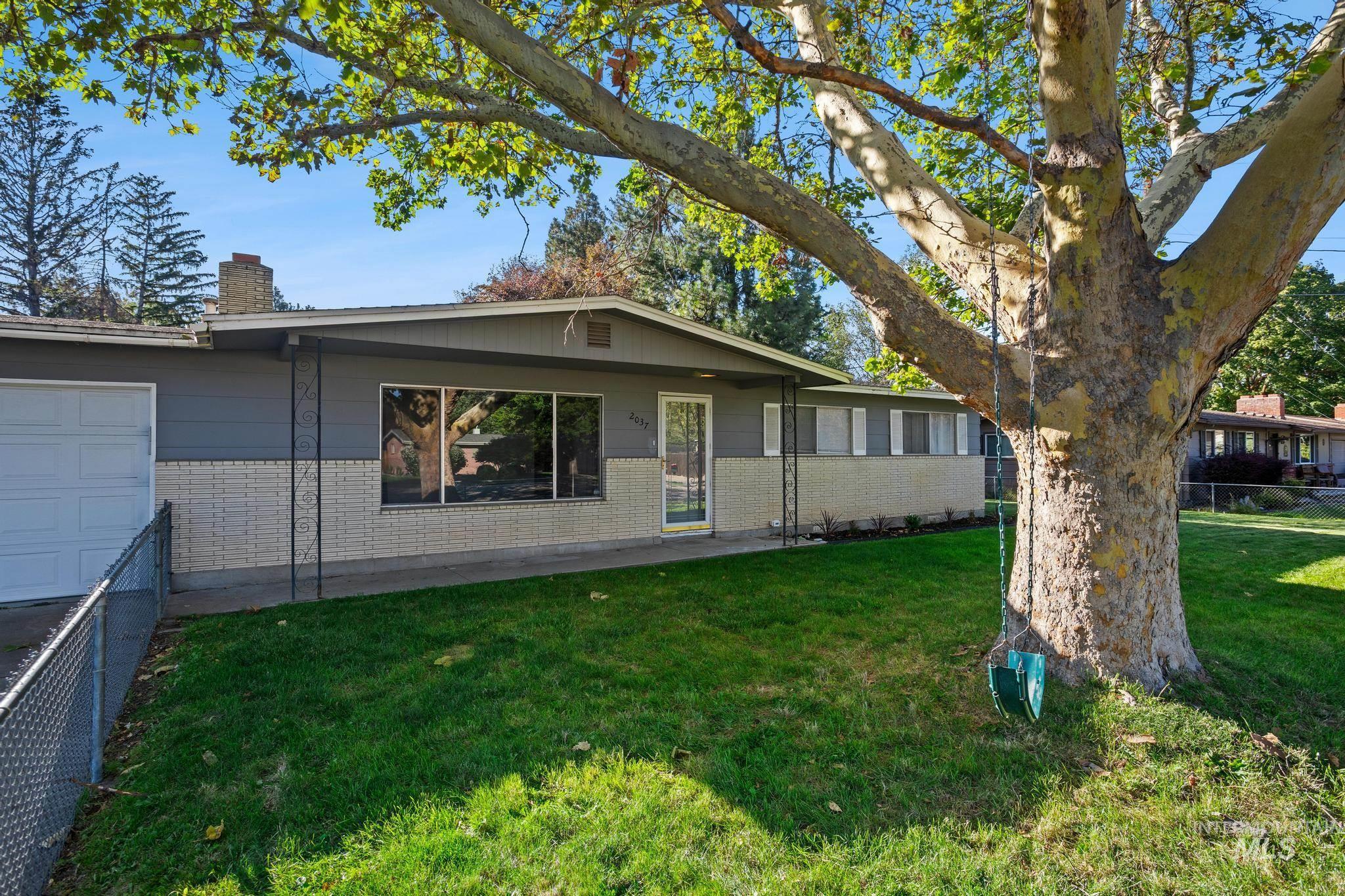 Exterior featuring a single-car garage, large front windows, a full glass entry door, and a brick-detailed facade
